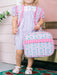 Child holding a patterned lunchbox with pink straps in a home setting