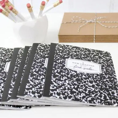 Set of black and white patterned notebooks with a visible brand label, arranged on a white surface.