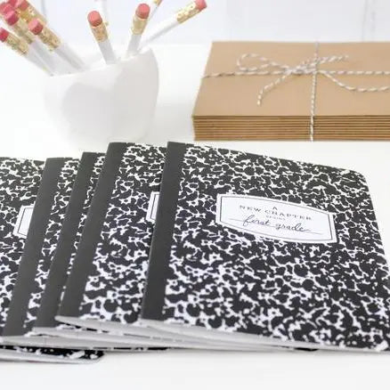 Set of black and white patterned notebooks with a visible brand label, arranged on a white surface.