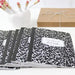 Set of black and white patterned notebooks with a visible brand label, arranged on a white surface.