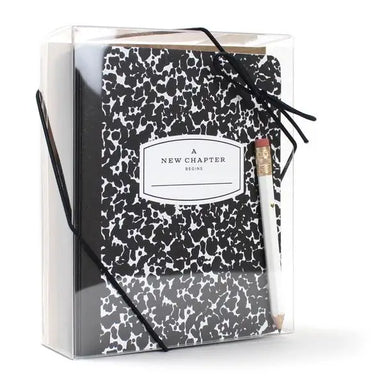 Black and white patterned notebook with 'A New Chapter Begins' label in a clear box on a white background
