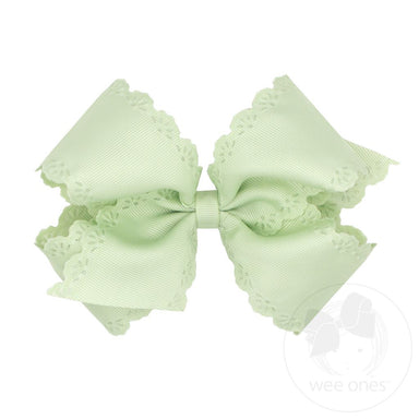 Light green hair bow with lace details on a white background