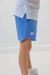 Blue shorts with a logo worn by a person on a white background