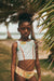 Young girl in a tropical bikini with palm leaves and a blurred background