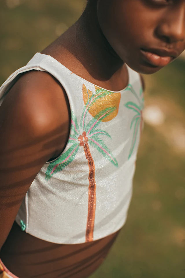 Young girl in a tropical bikini with palm leaves and a blurred 
