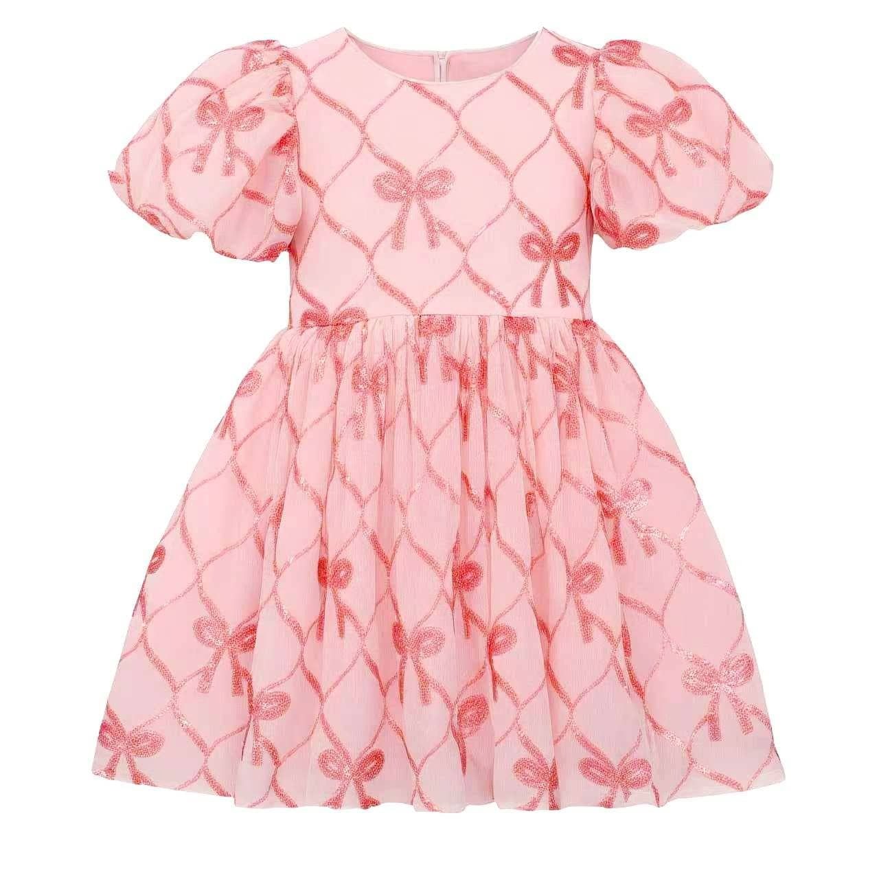 A pink girls' dress with short puff sleeves and a gathered skirt, featuring a repeating shiny bow and diamond lattice pattern.