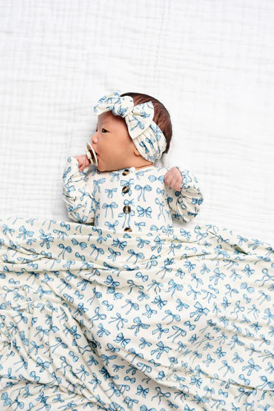 Baby swaddled in a blue and white patterned blanket with a matching headband.