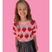 girl wearing pink puff sleeve sweater with knit strawberries