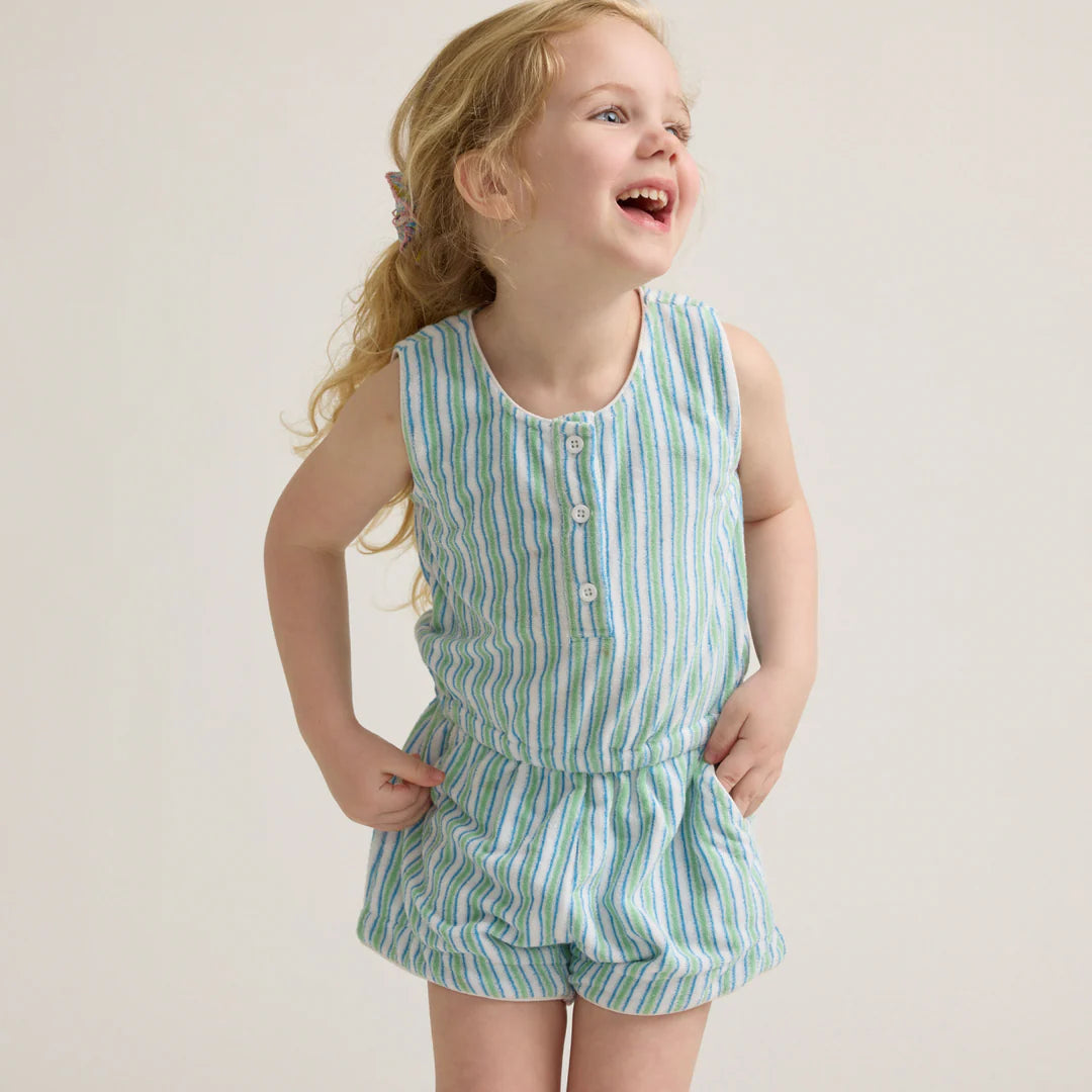 Child wearing a green and white striped outfit on a plain background