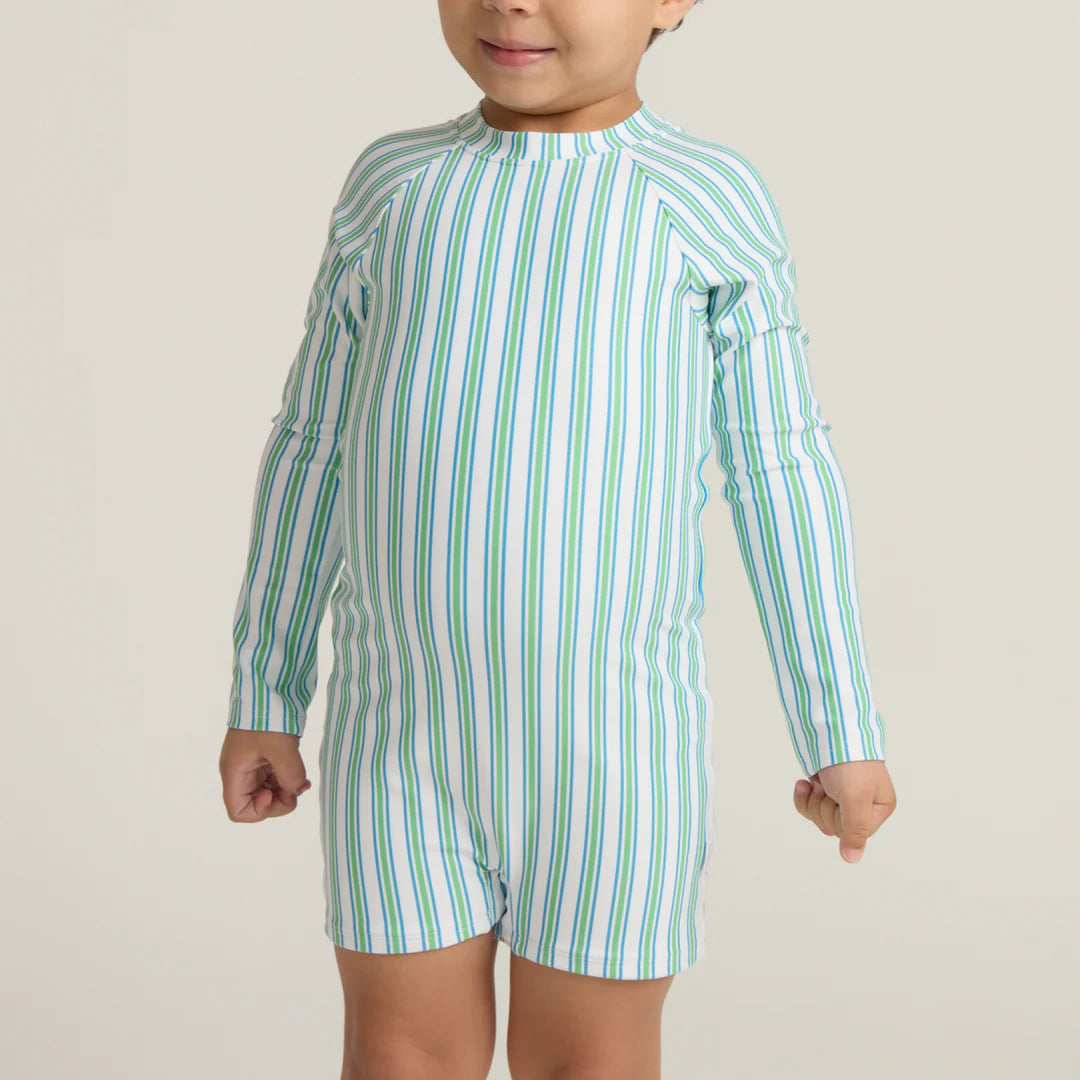 Child wearing a green and white striped swimsuit on a plain background
