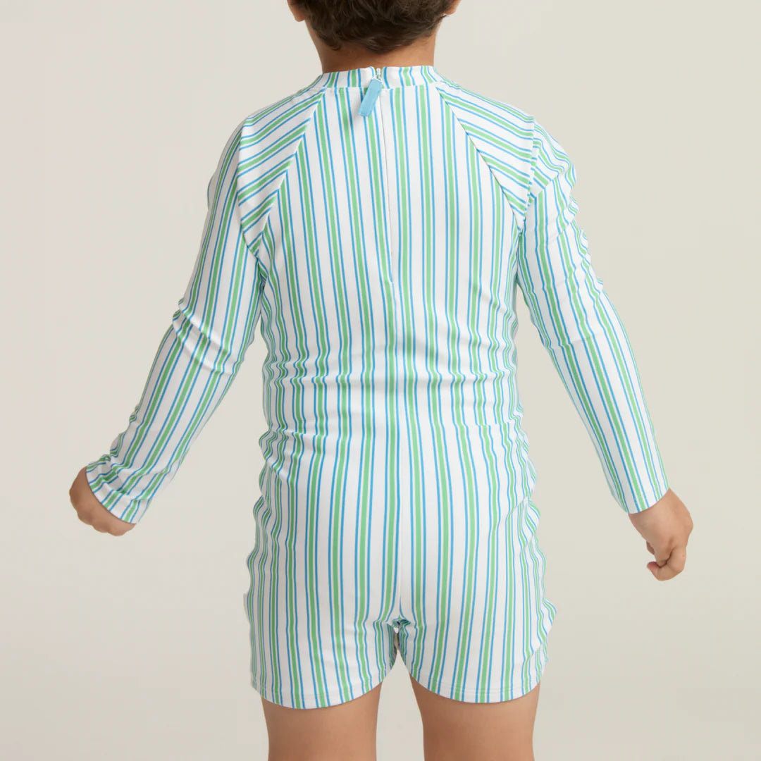Child wearing a green and white striped swimsuit on a plain background
