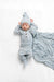 Newborn baby in grey and white striped outfit on a white textured blanket