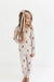 Young girl wearing a checkered pajama set with bear pattern on a white background
