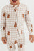 Child wearing a beige checkered onesie with teddy bear patterns on a white background