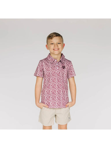 Young boy wearing a patterned shirt and beige shorts on a white background