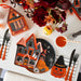 Halloween-themed table setting with haunted house plate, cutlery, and decorative items.
