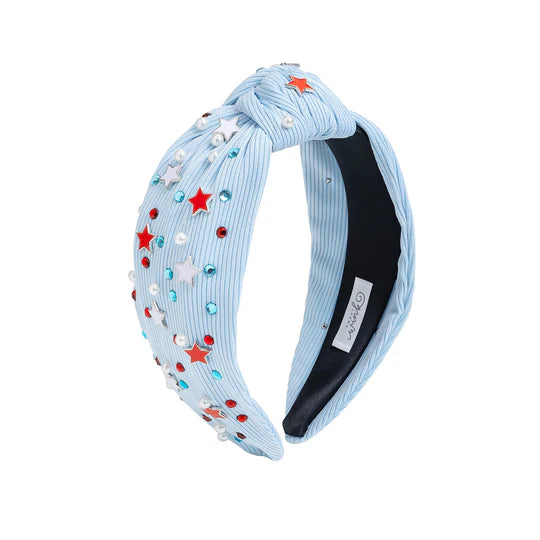 Light blue headband with star and bow decorations on a white background