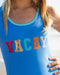 Blue girls swimsuit with Vacay sparkle across the front
