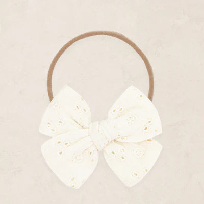 Vanilla eyelet headband on a beige background