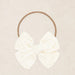 Vanilla eyelet headband on a beige background
