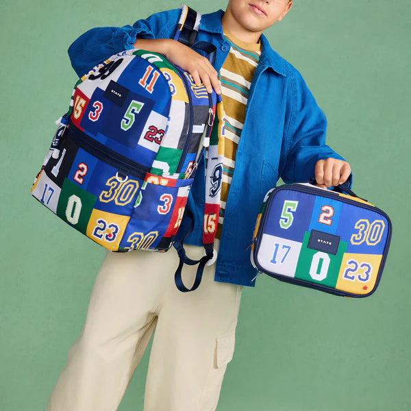 Boy holding Varsity Numbers Kane Backpack and Rodgers Lunchbox