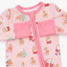 A baby long-sleeve sleep sack in light pink with a festive holiday print of Santa Claus, reindeer, and Christmas trees, featuring a pink zipper and matching pink cuffs.