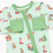 A baby zip-up sleeper in a light mint green color, decorated with a festive Christmas print featuring Santa Claus, reindeer, Christmas trees, and red stockings. The sleeper has two green pocket flaps on the chest and a green trim around the collar.