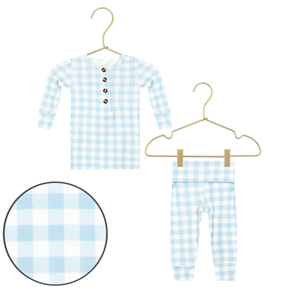 Blue and white checkered children's pajamas on hangers with a close-up of the fabric pattern.