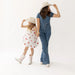 Woman and child wearing matching denim outfits with hats on a white background