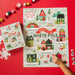Pippi Post Welcome To The North Pole 500 piece jigsaw puzzle showing Santa village with candy cane forest workshop and festive homes as a hand assembles it