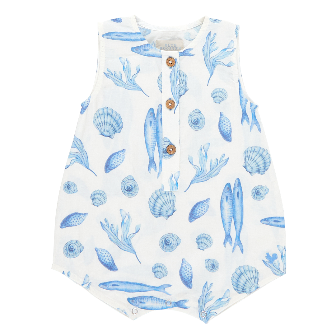 white sleeveless romper with blue seashell and fish print and 3 buttons down the middle