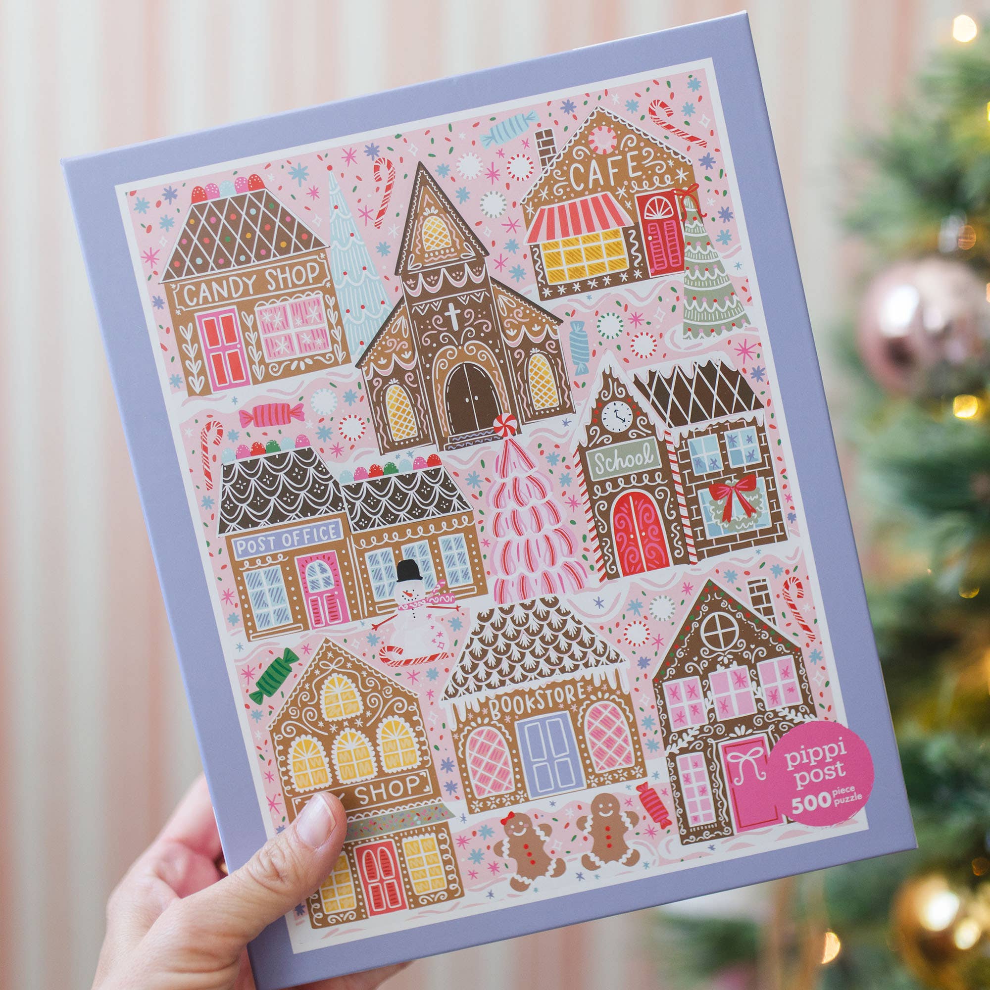 Pippi Post 500 piece Christmas jigsaw puzzle showing a colorful gingerbread village with candy shop cafe school post office bookstore and festive holiday trees