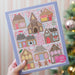 Pippi Post 500 piece Christmas jigsaw puzzle showing a colorful gingerbread village with candy shop cafe school post office bookstore and festive holiday trees