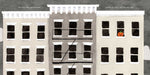 Illustration of a building facade with windows, one of which has a pumpkin, on a gray background.