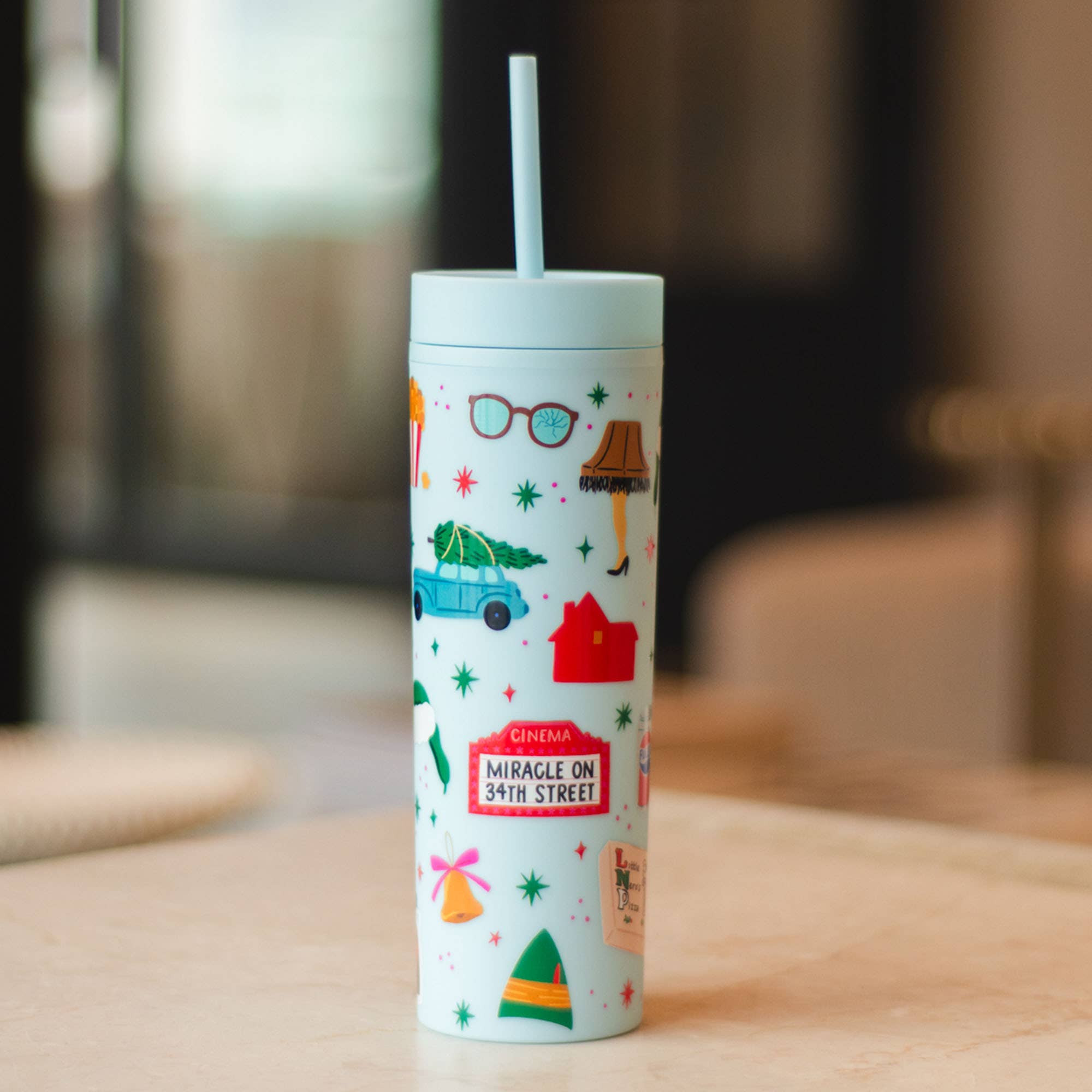 Pippi Post Christmas movie themed 16 ounce skinny acrylic tumbler with straw and illustrated holiday icons on a pale background