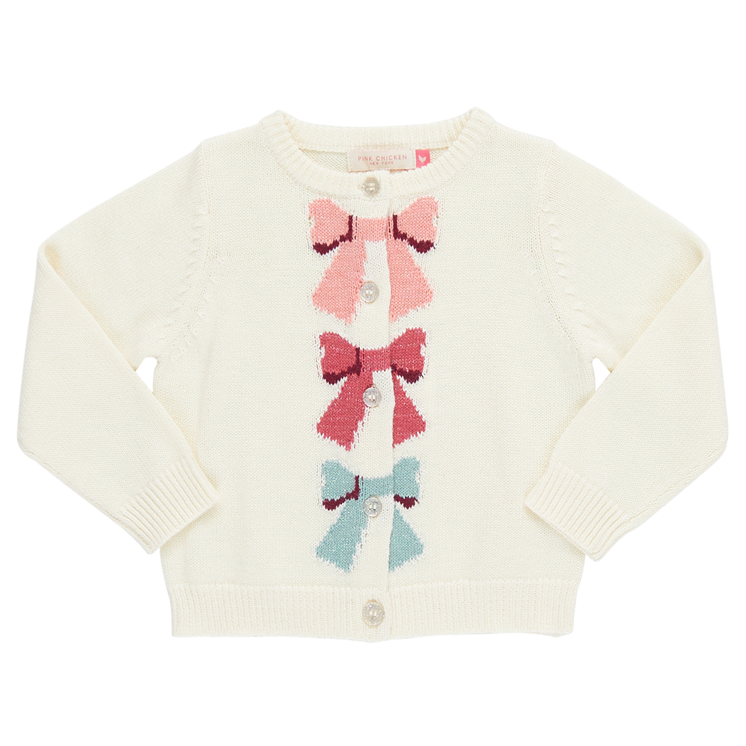 cream colored cardigan with sparkle buttons and pink, red and blue knit bows down the middle