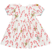 back of white puff sleeve dress with red candy cane print and 3 blue bows down the center