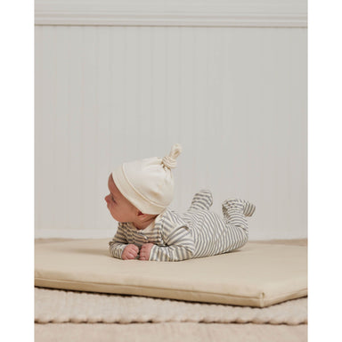 baby wearing ivory knotted baby hat while doing tummy time