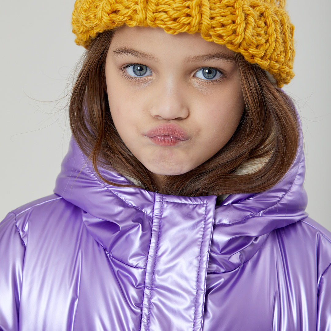 girl wearing purple metallic puffer with yellow beanie