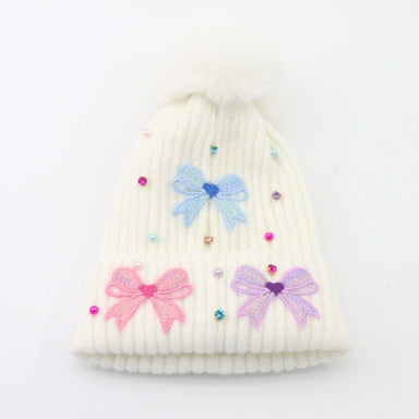 White knit beanie with colorful bow decorations on a white background