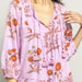 up close view of woman wearing lavender 3/4 sleeve midi dress with orange poppy print